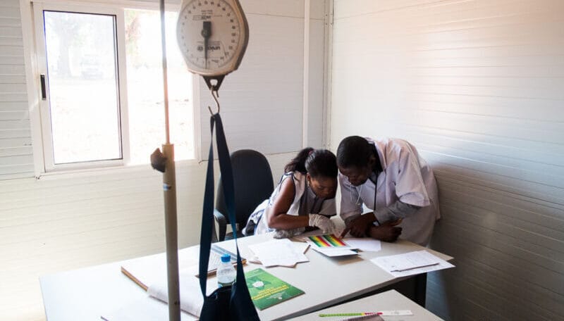 Una enfermera y su supervisor revisan guías clínicas en un centro de salud de Angola, ejemplo del trabajo cotidiano de la acción humanitaria